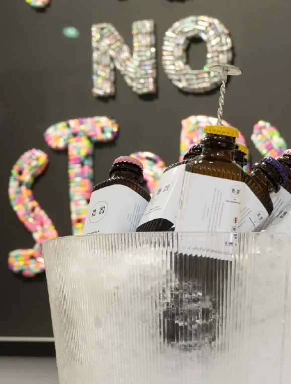 19/29 bottles in an ice bucket in front of beaded artwork