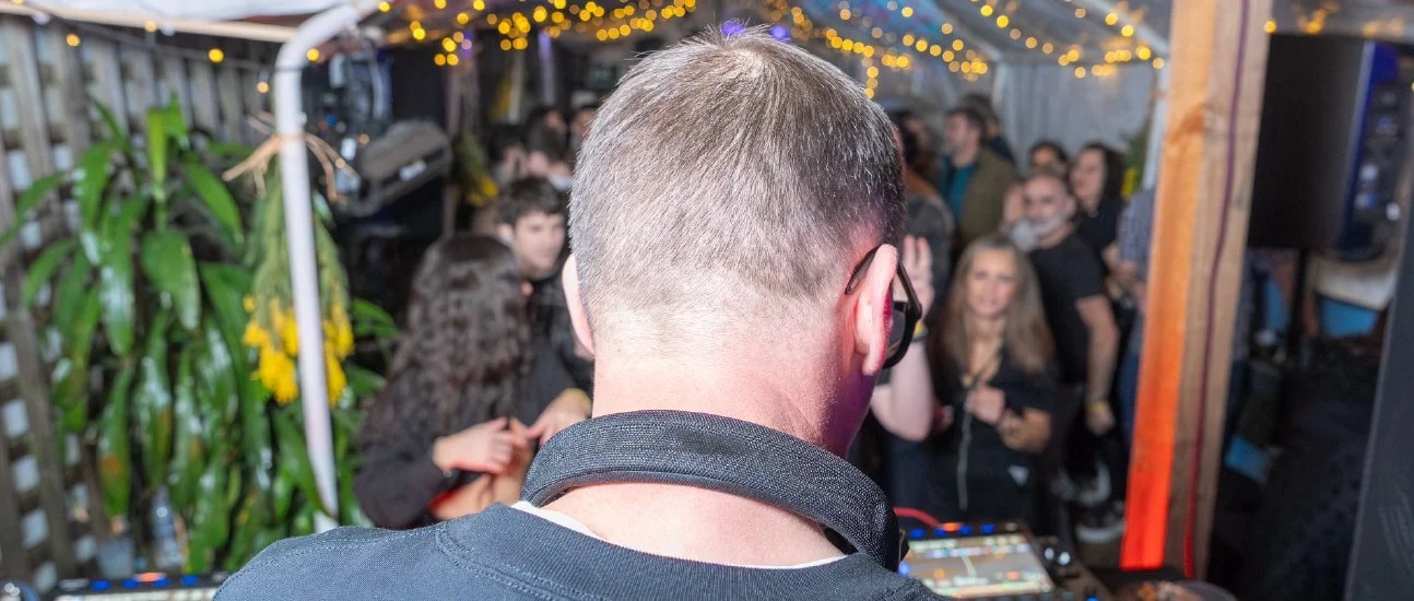 DJ seen from behind playing to the crowd