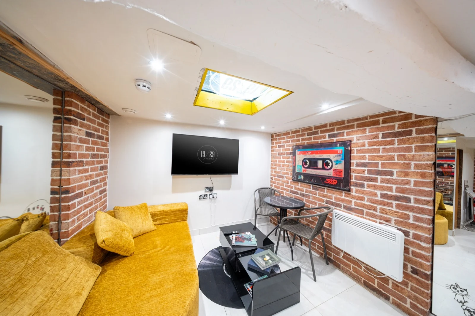 The lounge at the 19/29 shop in Hertford: yellow sofas and a brick wall