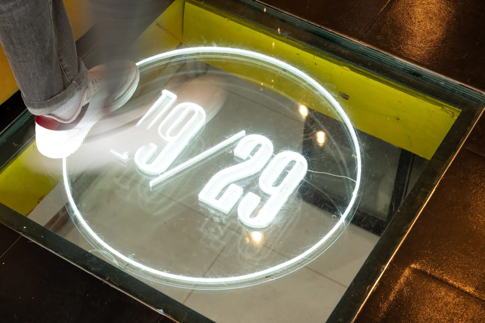 The glowing 19/29 sign set into the shop floor