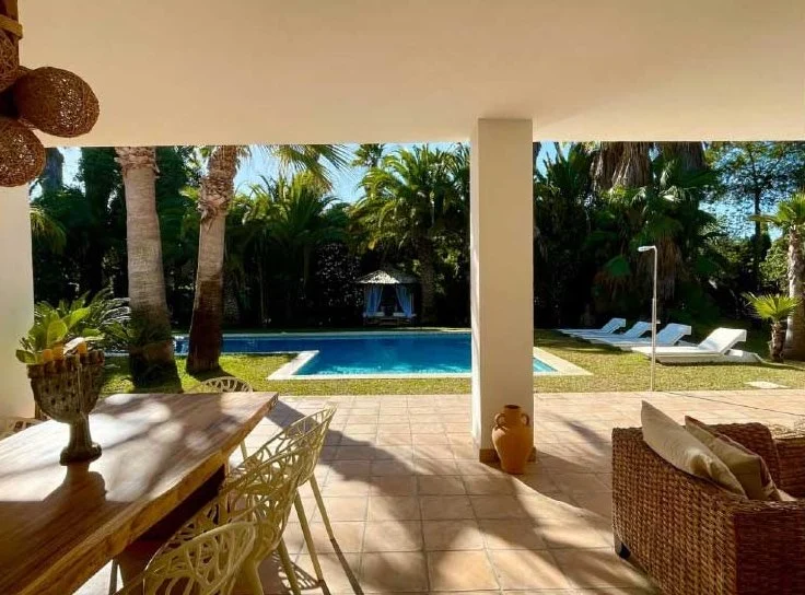Villa terrace looking out on the pool and palm trees