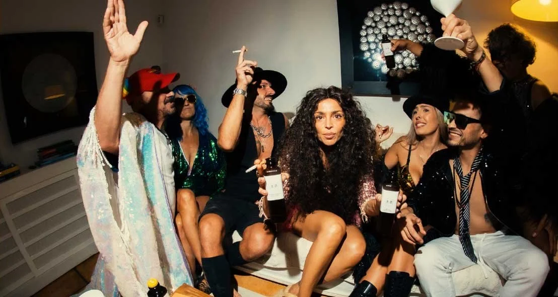 Guests posing on a sofa at the villa party with 19/29 bottles