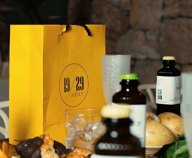 Yellow 19/29 Agency bag with bottles and glasses on a table