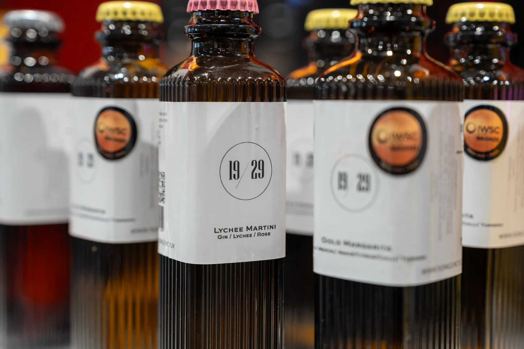 19/29 bottles with coloured crown caps lined up at Spring Fair