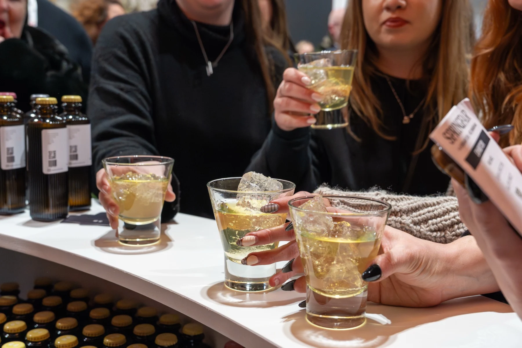 Guests holding tumblers of pale cocktails at the 19/29 bar