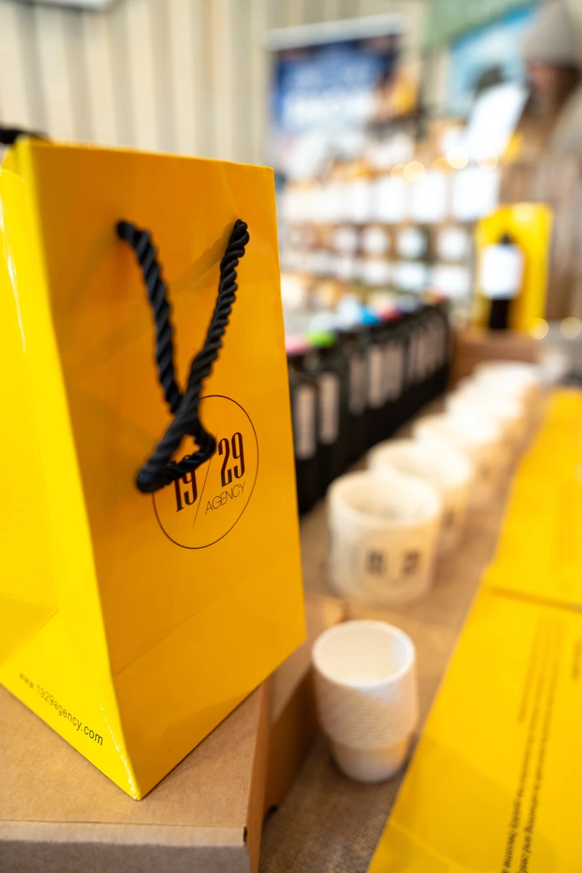 A yellow 19/29 gift bag on the bar with 19/29 bottles