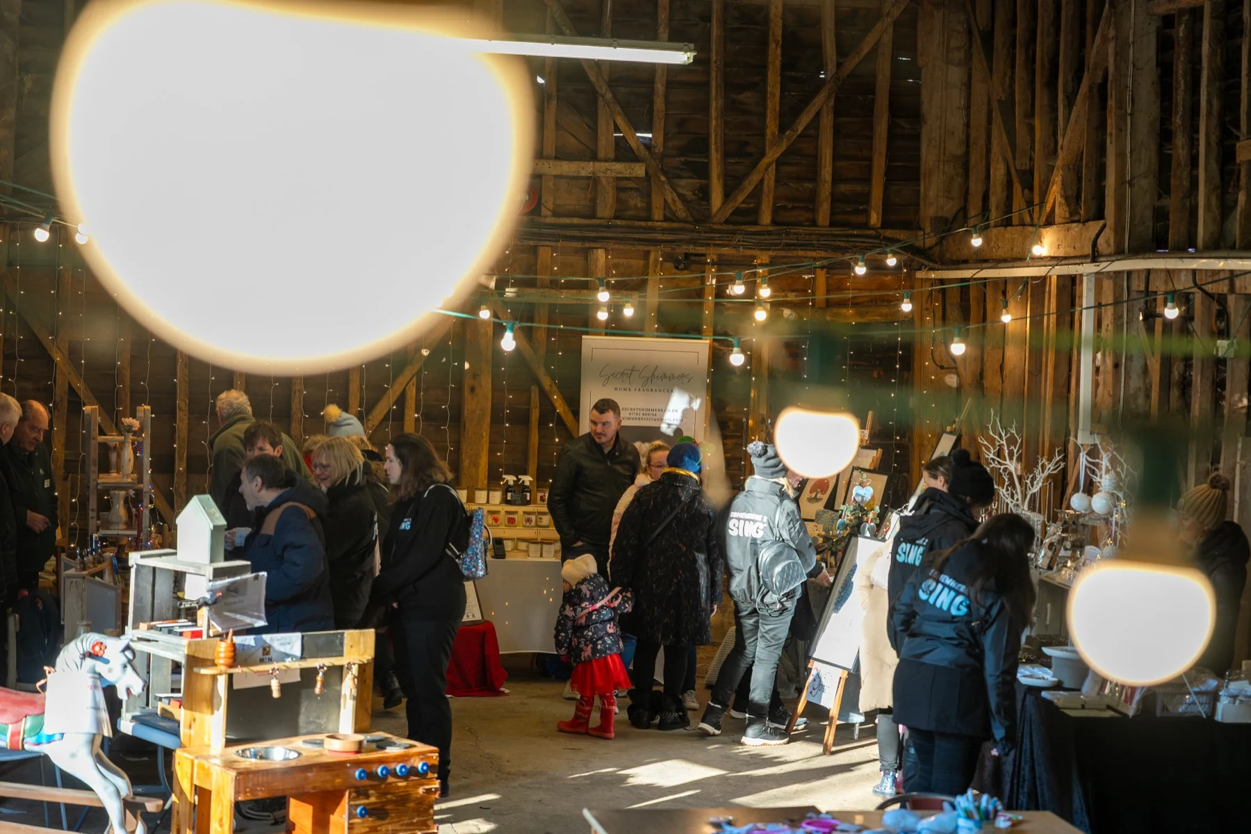 Visitors browsing stalls in the barn market